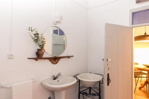 uma casa de banho branca com um lavatório e um espelho em Casa de campo em Venda do Duque no Vimieiro