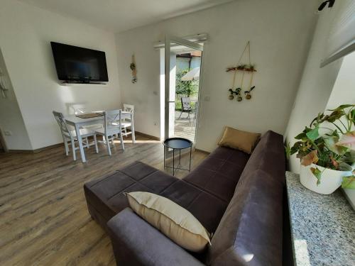 a living room with a brown couch and a table at Apartment AlpiPond in Kamnik
