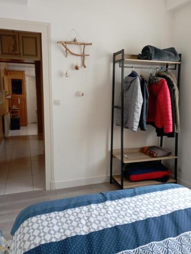 a bedroom with a bed and a rack of clothes at chambre chez l habitant Liebmann in Saujon