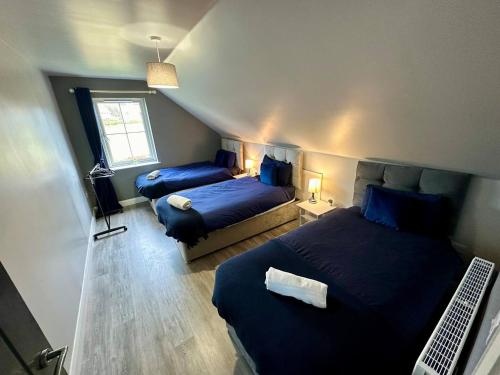 1 dormitorio con 2 camas y ordenador. en Forest View House & Hot Tub Sleeps 9, en Ballynameen