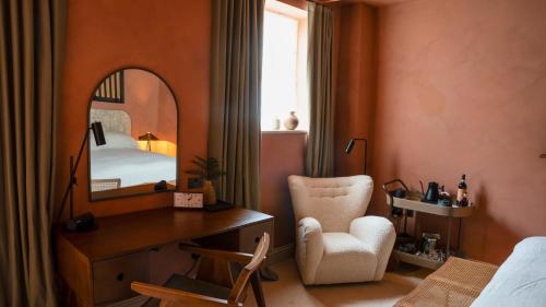 a bedroom with a bed and a mirror and a chair at BULL Burford in Burford