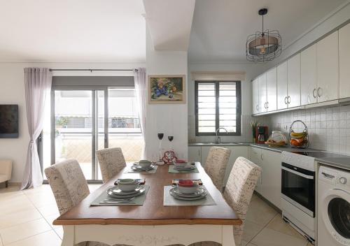a kitchen with a wooden table with chairs and a tableasteryasteryasteryasteryastery at Elegant Apt 50meters Close Acropolis in Athens