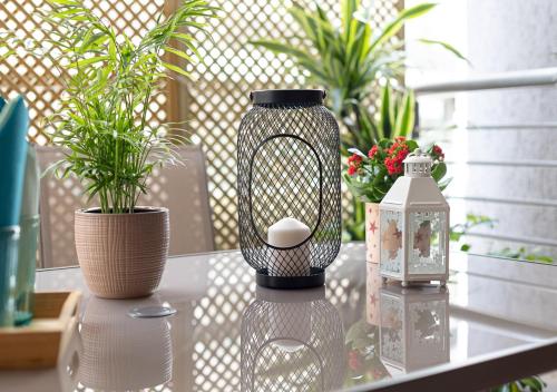 a bird cage sitting on a table with potted plants at Elegant Apt 50meters Close Acropolis in Athens