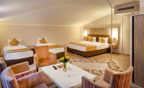a hotel room with two beds and a table and chairs at Orya Hotel in Istanbul
