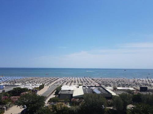 una playa con muchas sombrillas y el océano en Hotel Delfino, en Milano Marittima