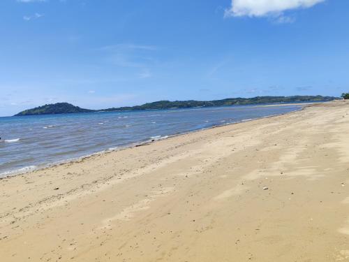a sandy beach with the ocean in the background at 7 COCOTIERS F2 terrasse jardin plage privée avec vue mer in Ambaro