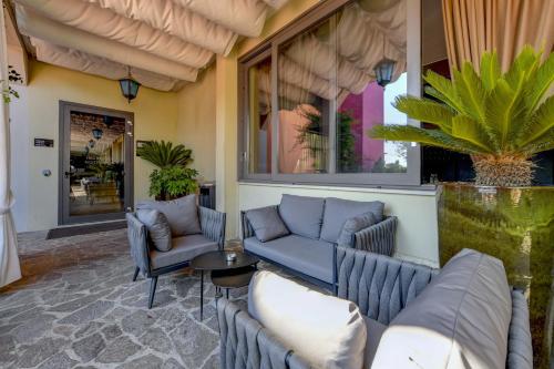 a patio with couches and a table and chairs at Albergo Locanda Primavera in Rodengo Saiano