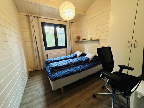 een kamer met een bed en een stoel. bij BPW 1155 - Bospark Wolfsven in Mierlo