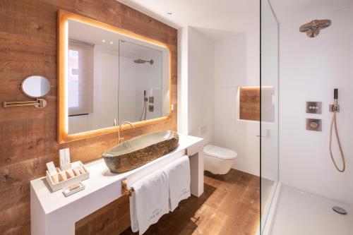 a bathroom with a sink and a mirror at Hotel Cala del Pi - Adults Only in Platja  d'Aro
