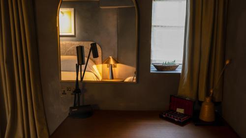 a bedroom with a mirror and a bed and a window at BULL Burford in Burford