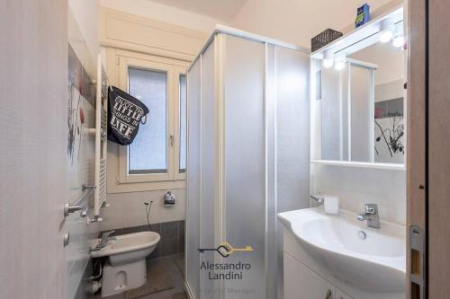ein Bad mit einem Waschbecken, einem WC und einem Fenster in der Unterkunft Casa Laura comodissima al centro e spiagge in Diano Marina