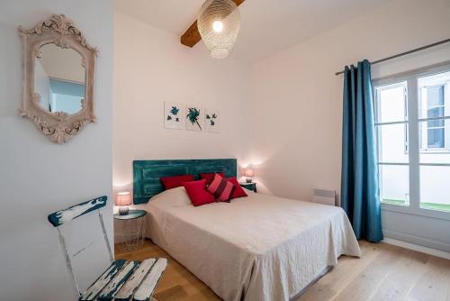 - une chambre avec un lit doté d'oreillers rouges et d'un miroir dans l'établissement Le Shabby Chic, Beau T2, Patio, Centre Ville, à Montpellier