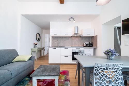 une cuisine et un salon avec un canapé et une table dans l'établissement Le Shabby Chic, Beau T2, Patio, Centre Ville, à Montpellier