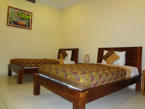two beds in a hotel room with two beds sidx sidx sidx at Nami House in Ubud