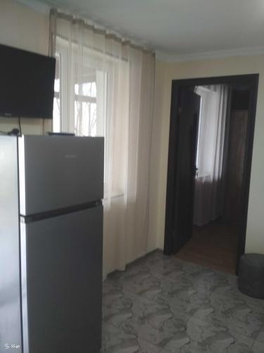 a kitchen with a refrigerator and a door to a room at Borjomi forest in Borjomi