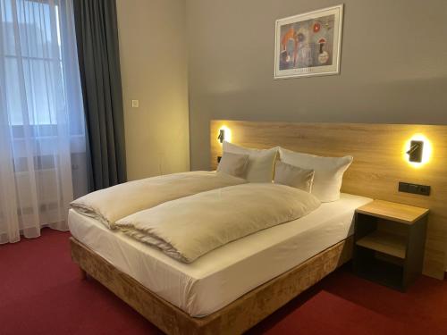 um quarto com uma grande cama branca e uma cabeceira em madeira em Best Western Comfort Business Hotel Düsseldorf-Neuss em Neuss