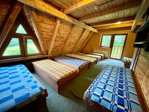 a room with three beds in a log cabin at Bacówka pod Honem in Cisna