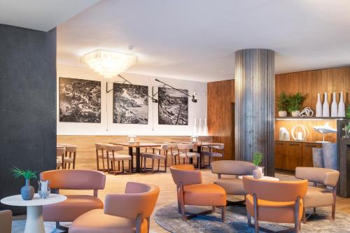 a waiting area with chairs and tables and a dining room at Hotel Cala del Pi - Adults Only in Platja  d'Aro