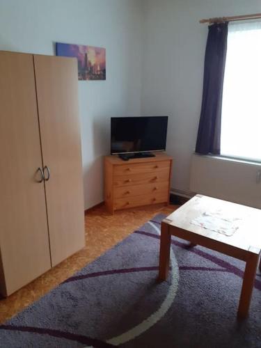 ein Wohnzimmer mit einem TV und einem Couchtisch in der Unterkunft Monteurzimmer Brunsbüttel Süd in Brunsbüttel