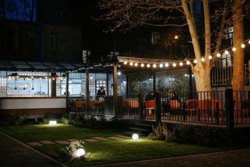 a restaurant at night with lights and a tree at Twenties Hotel in Tbilisi City