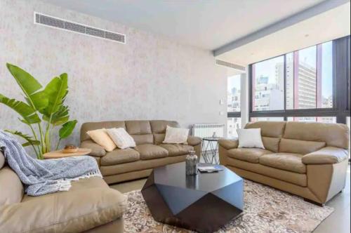 ein Wohnzimmer mit einem Sofa und einem Couchtisch in der Unterkunft Livloft 2-BR in Mar Mikhael in Beirut