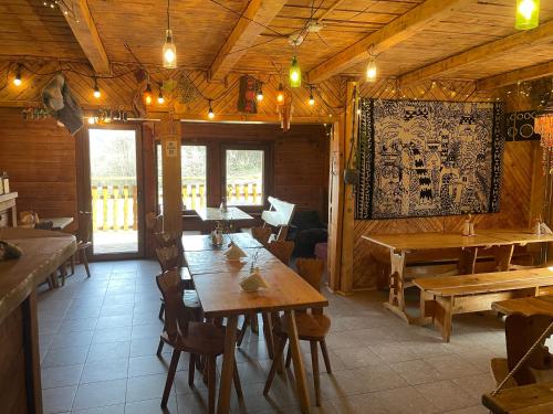 un restaurante con mesas de madera y sillas en una habitación en Bacówka pod Honem, en Cisna