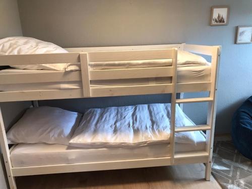 a bunk bed with white bunk beds in a room at fewo-friends in Reinfeld