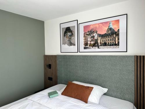 1 dormitorio con 2 fotos colgando sobre una cama en Aspire Palais Recklinghausen, Trademark Collection by Wyndham, en Recklinghausen