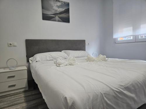ヒホンにある1A114 Apto moderno en Gijónのベッドルーム(大きな白いベッド1台、ナイトスタンド付)