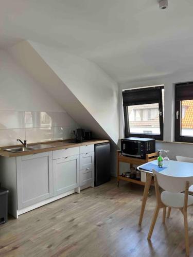 eine Küche mit weißen Schränken und einem Tisch im Zimmer in der Unterkunft Casa Studioapartment mit kostenlosen Parkplätzen in Bremen