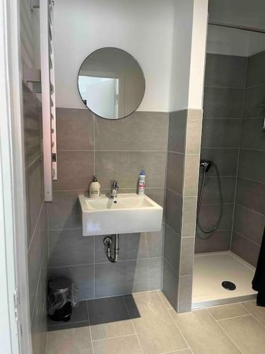 ein Bad mit einem Waschbecken, einer Dusche und einem Spiegel in der Unterkunft Casa Studioapartment mit kostenlosen Parkplätzen in Bremen