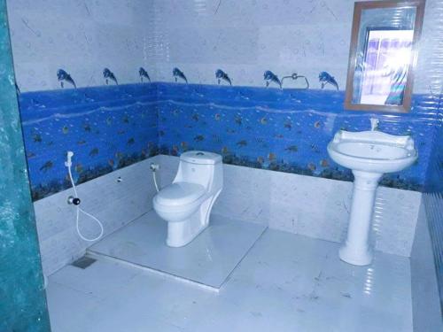a bathroom with a toilet and a sink at Danak Farm And Resort in Sasan Gir