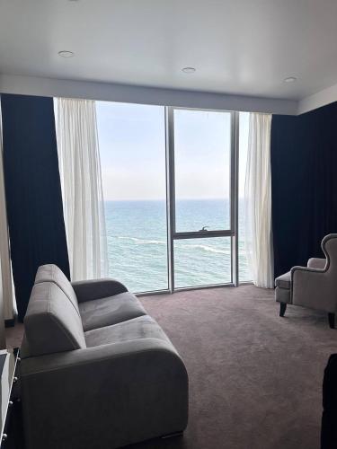 a living room with a couch and a large window at Maristella Marine Residence in Odesa