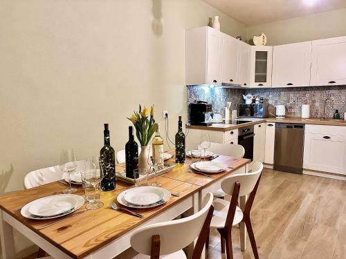 a kitchen with a wooden table with wine bottles at Winnica Nad Jarem in Sandomierz