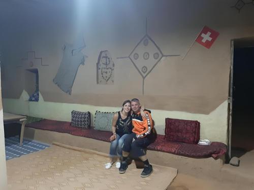 a man and a woman sitting on a couch at Auberge Dinosaur Kem Kem in Tafraoute Sidi Ali