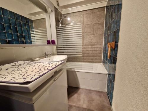 une salle de bain avec un lavabo et une baignoire dans l'établissement Studio cabine rénové, équipé pour 4 pers., parking privé - Saint Cyprien - FR-1-225D-5, à Saint Cyprien Plage