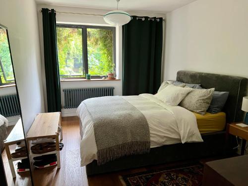 - une chambre avec un lit et une fenêtre dans l'établissement Urban Oasis Chic 1BR Flat with Spacious Garden, à Londres