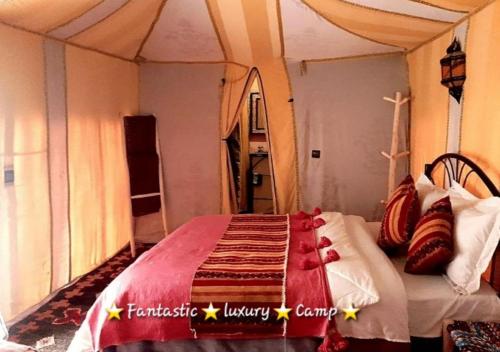 a bedroom with a bed in a tent at Fantastic Luxury Camp in Merzouga