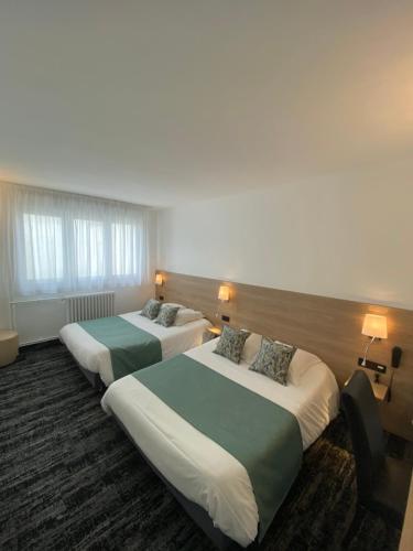 ein Hotelzimmer mit 2 Betten und 2 Lampen in der Unterkunft Hotel du Louvre in Cherbourg en Cotentin