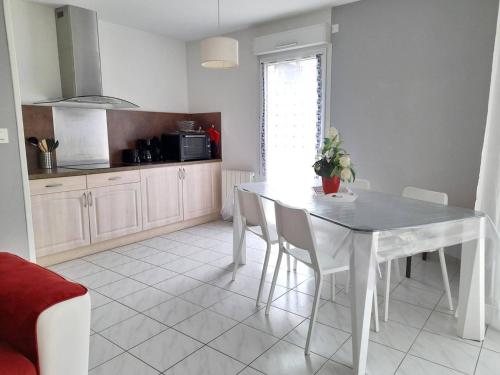 une cuisine avec une table et des chaises dans une pièce dans l'établissement Appartement charmant près de la plage avec garage et terrasse - Idéal pour famille et amis - FR-1-392-233, à La Turballe