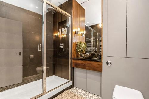 uma casa de banho com um chuveiro, um WC e um lavatório. em Luxurious & Spacious Townhouse em Londres