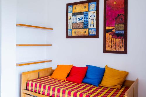 un banco con almohadas coloridas en una habitación en Trilocale 37 Residence La Giungla, en Falerna