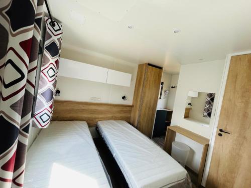 a small room with two beds in a room at Camping de la Plage in Marck