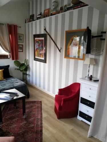 - un salon avec une chaise rouge et une commode dans l'établissement les tuilieres, à Limoges