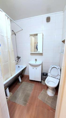 biała łazienka z toaletą i umywalką w obiekcie Аэропорт Астана 5 минут юг1 233 w mieście Prigorodnyy