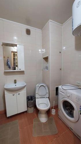 a bathroom with a toilet and a washing machine at Аэропорт Астана 5 минут юг1 233 in Prigorodnyy