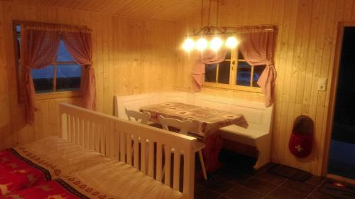 Zimmer mit Tisch und Bett in der Unterkunft SwissCottages Blockhaus in Schönengrund