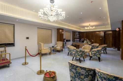 a waiting room with chairs and a table at De Crown Inn in Jogīkuti