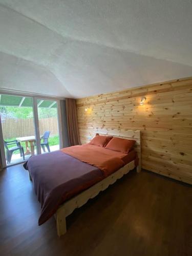 ein Schlafzimmer mit einem Bett mit einer Holzwand in der Unterkunft MAGNOLİA in Sile