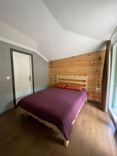 ein Schlafzimmer mit einem großen Bett und einer Holzwand in der Unterkunft MAGNOLİA in Sile